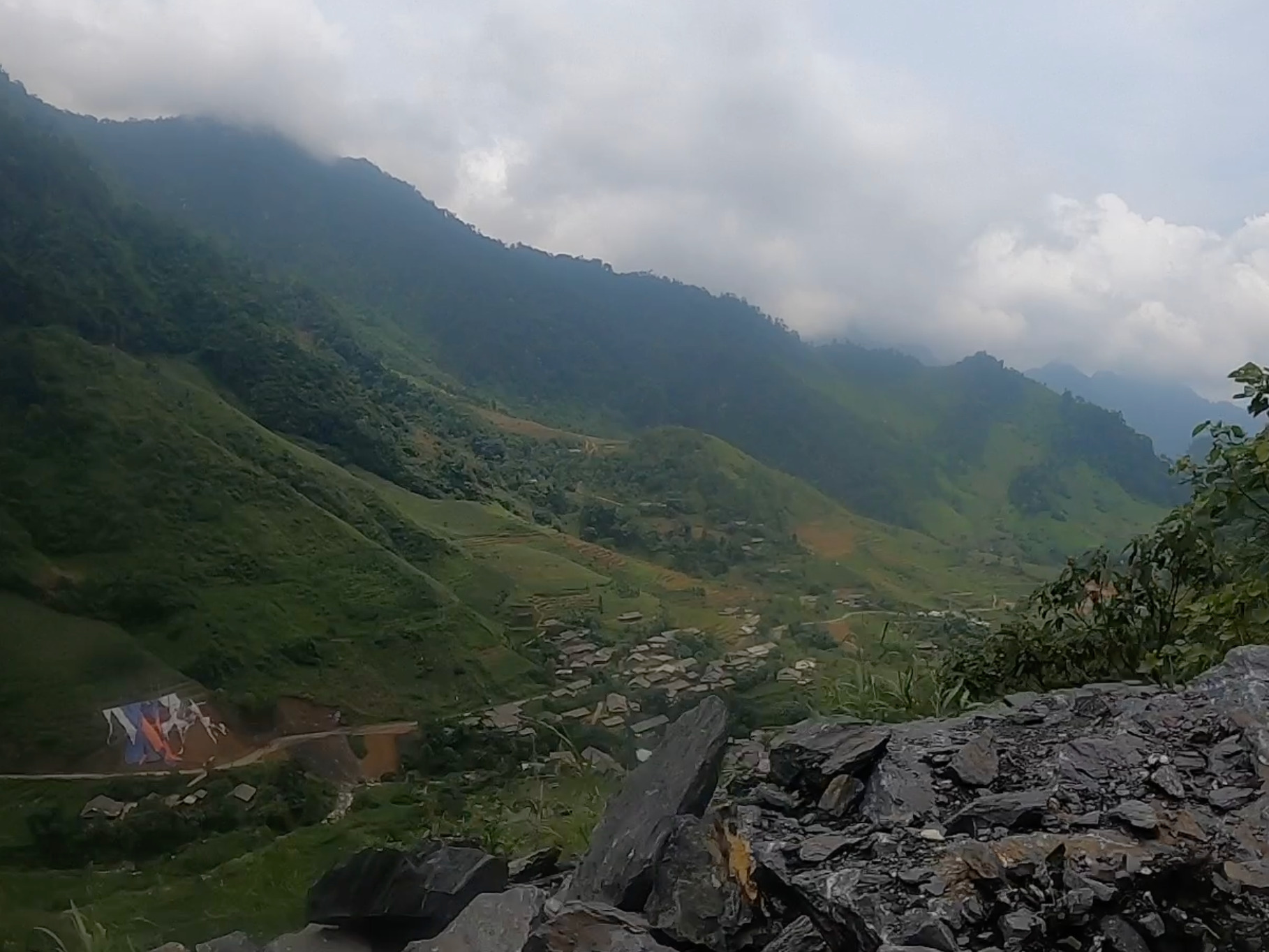 Mountain valley and village beneath misty peaks