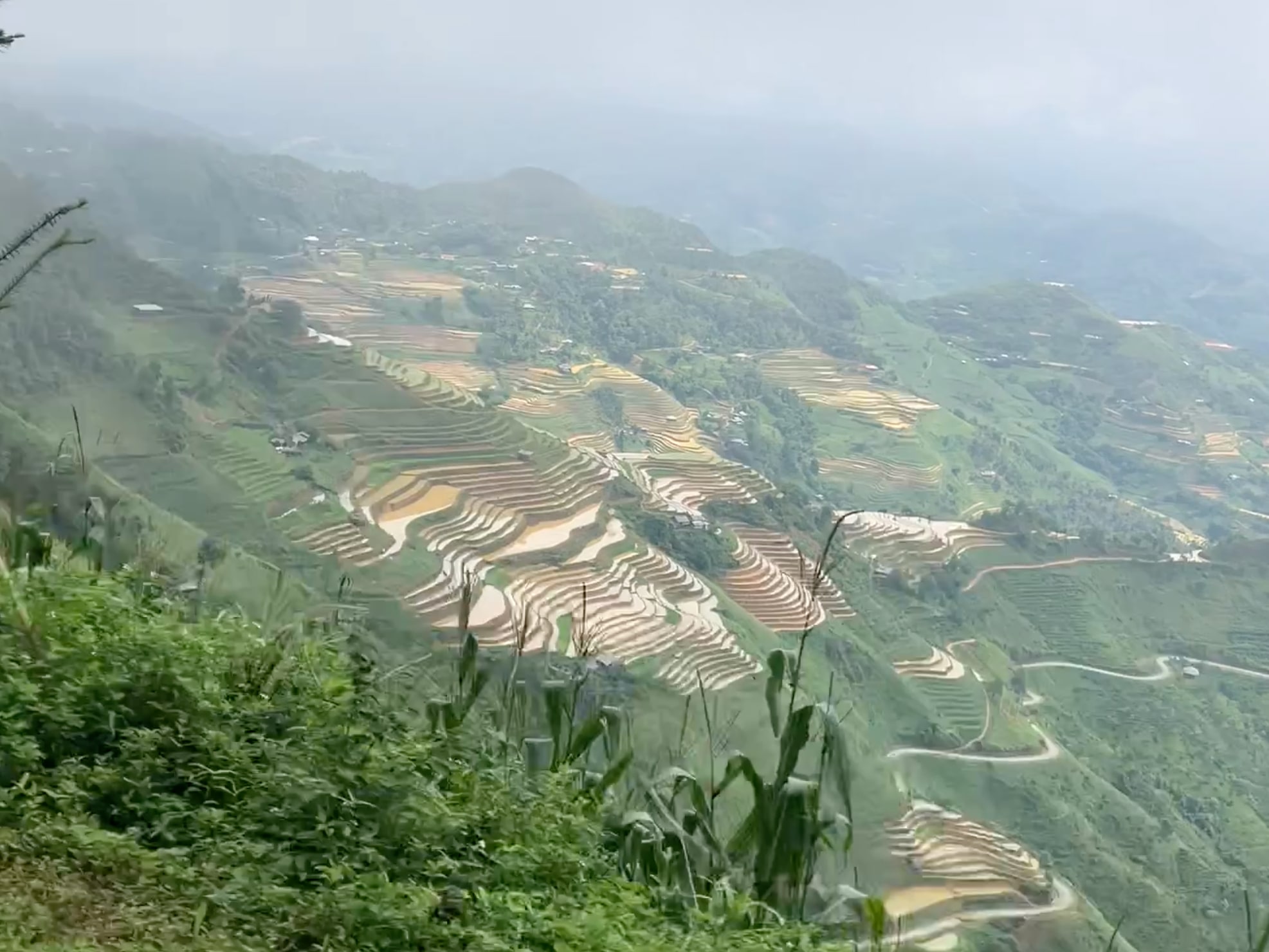 Terraced fields spread across green mountain slopes.