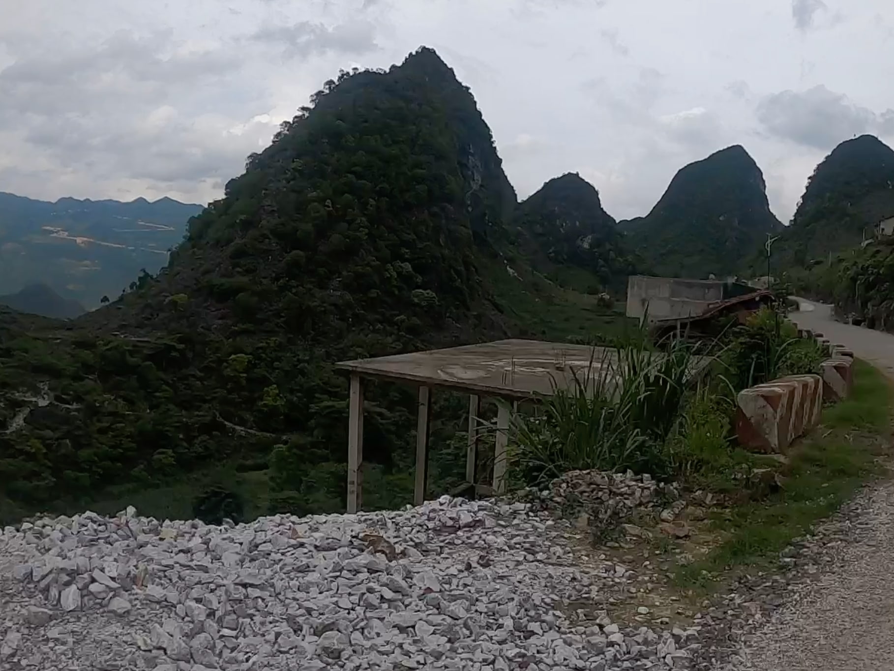 A winding road crosses a steep green mountain pass.